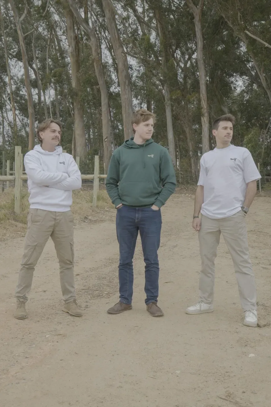 Three friends standing in front of tall eucalyptus trees