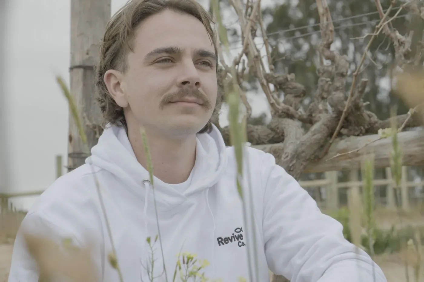 Wearing the white Revive Co. hoodie among the vines